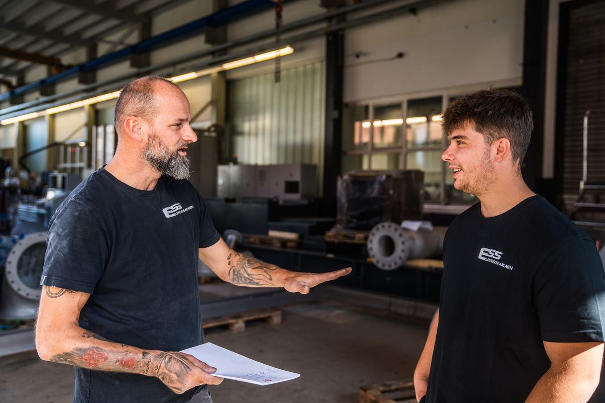 Zwei ESS-Kollegen besprechen einen Auftrag in der Werkstatt