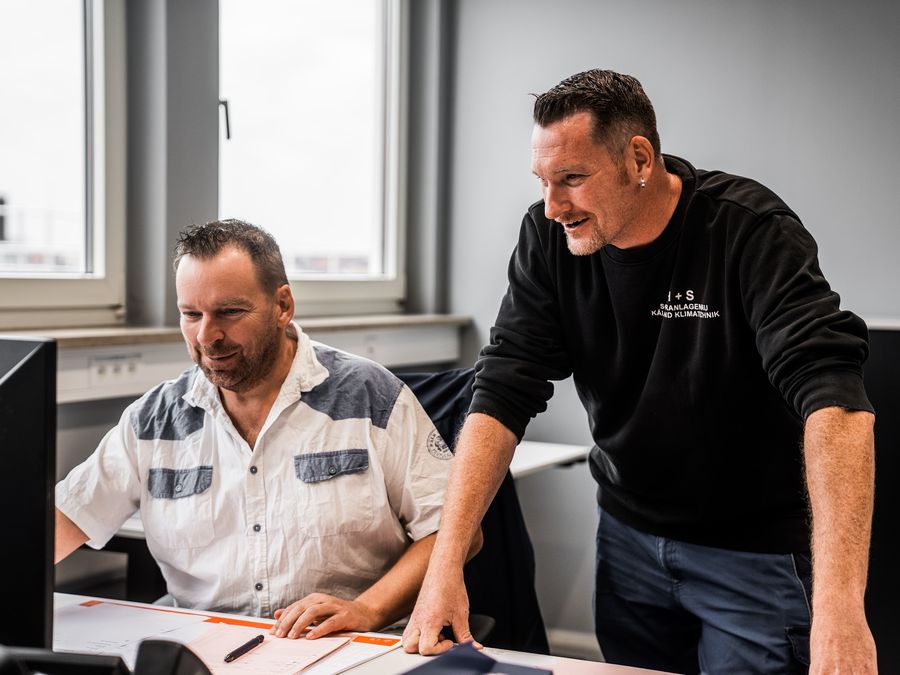 Zwei ESS-Mitarbeiter besprechen eine Elektroplanung am Bildschirm